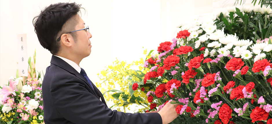 家族葬のトワーズ葬儀スタッフが葬式祭壇の生花を整えている様子